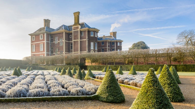The Cherry Garden showing frosty lavender in winter with Ham House and a blue sky in the background